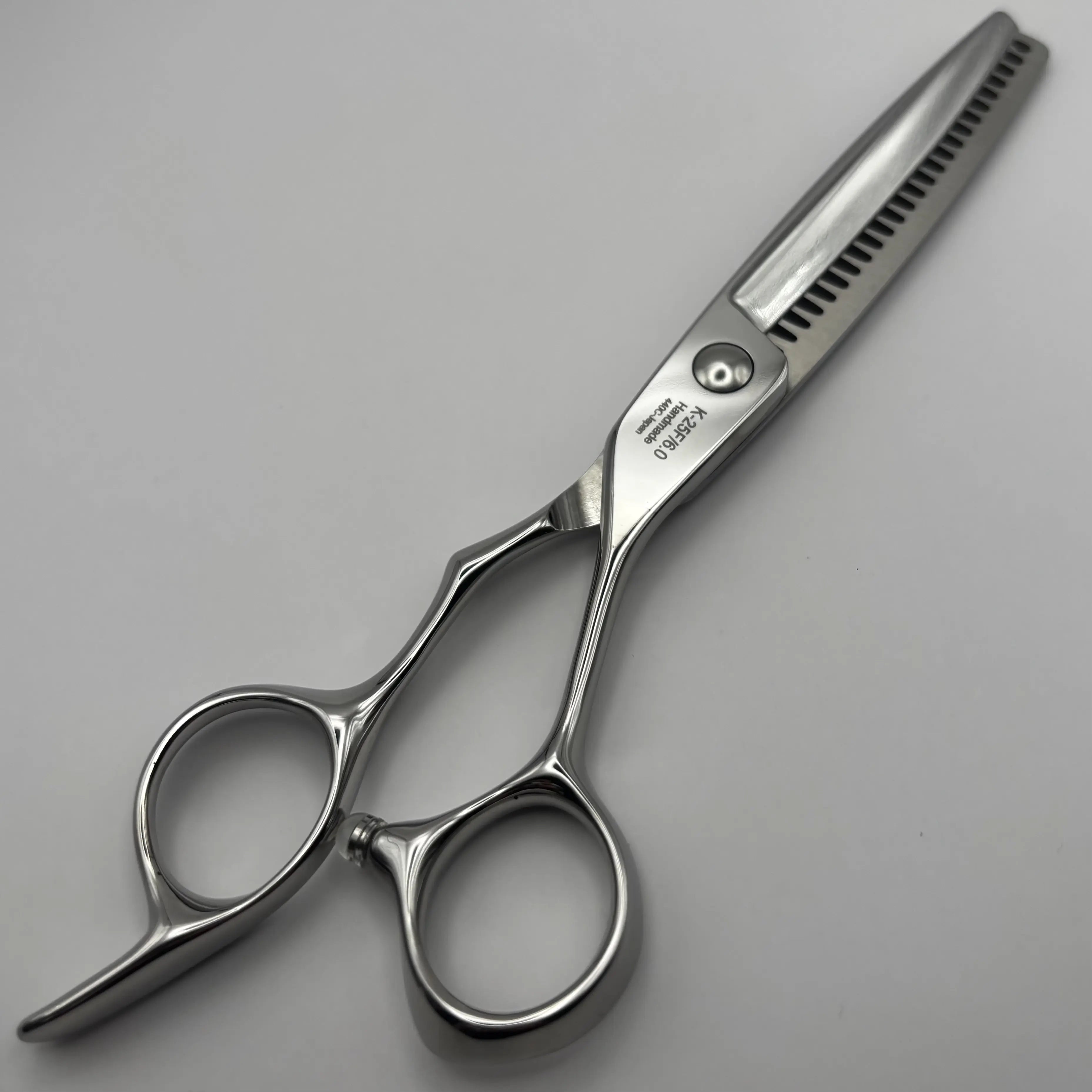 A pair of silver K-25F hair shears with a straight blade featuring a fine saw-tooth edge, shown on a neutral light grey background.