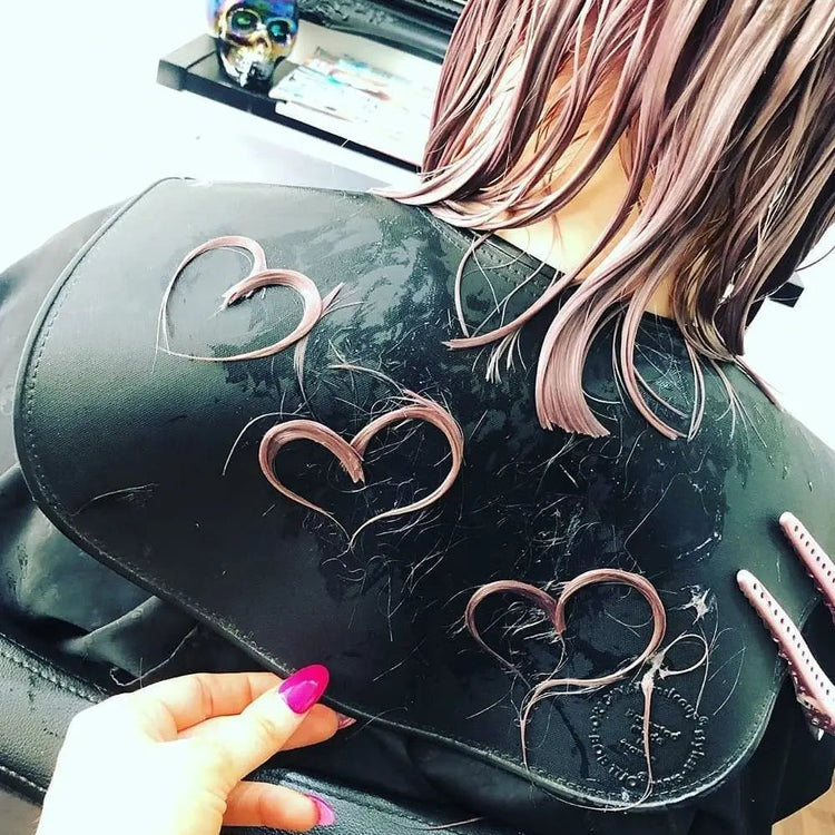 Black hair salon chair with hair in heart shapes, having had their hair cut using Akito's