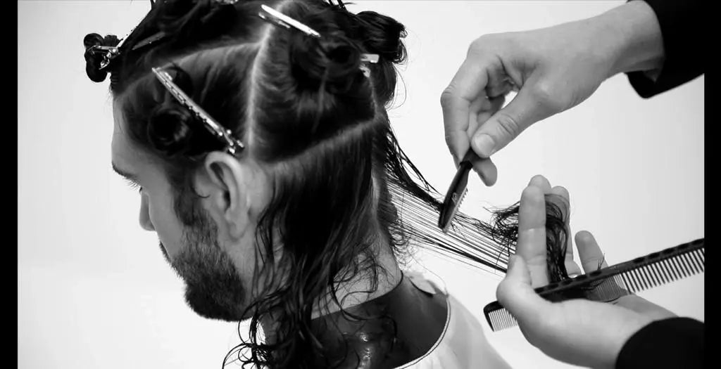 Person getting a haircut with a comb and akito scissors, black and white photo