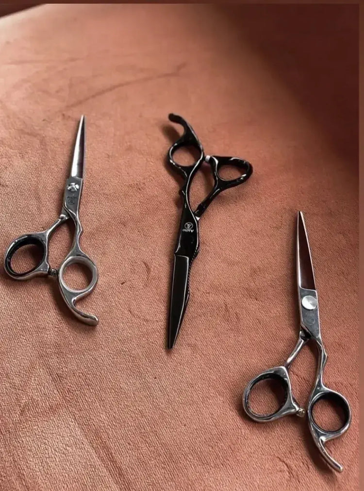 Three pairs of scissors on a textured brown surface