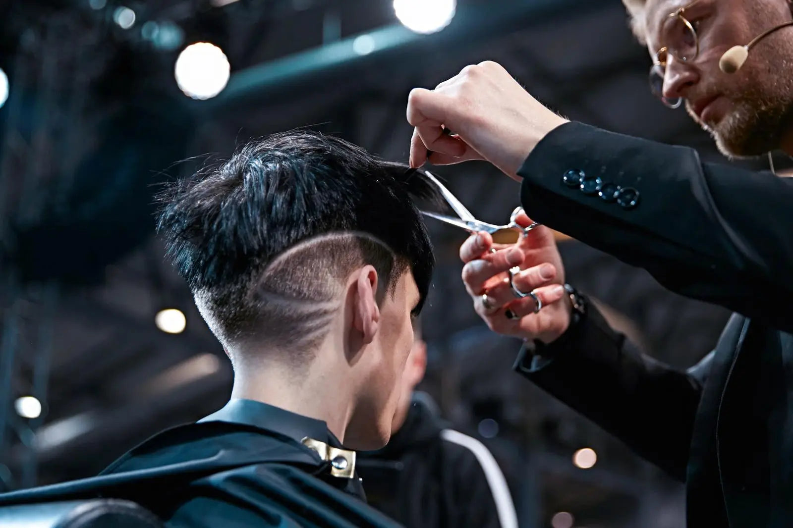 Barber cutting a customer's hair with Akito scissors in a salon setting