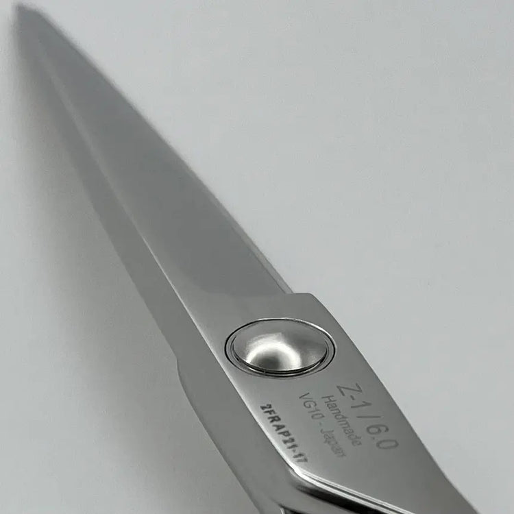 Close-up of a pair of Akito scissors on a light gray background