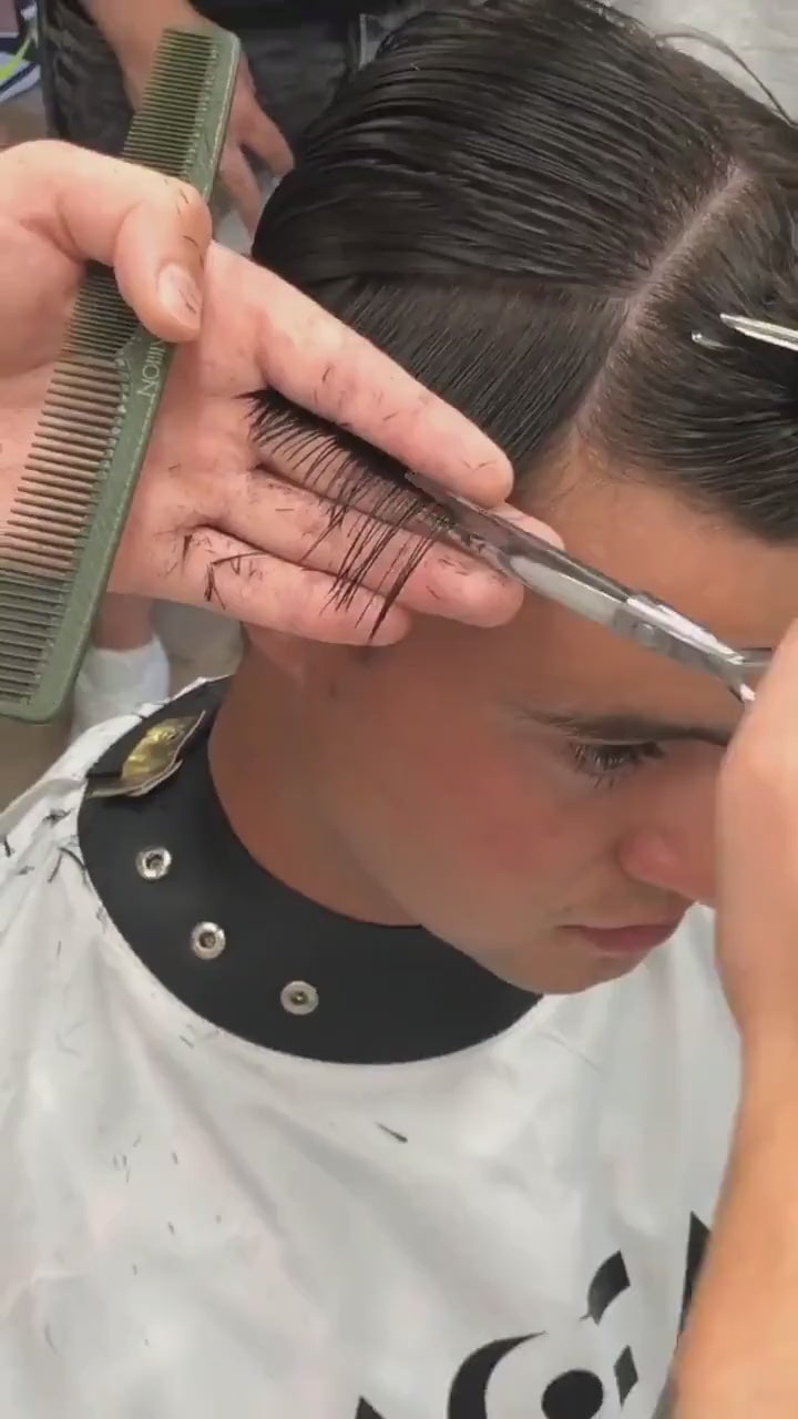 barber up close to cutting male customers hair using silver Akito F-2